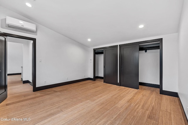 1808 Garfield Bay Rd, Sagle, ID 83860 - unfurnished bedroom featuring an AC wall unit, light wood-style floors, baseboards, and recessed lighting