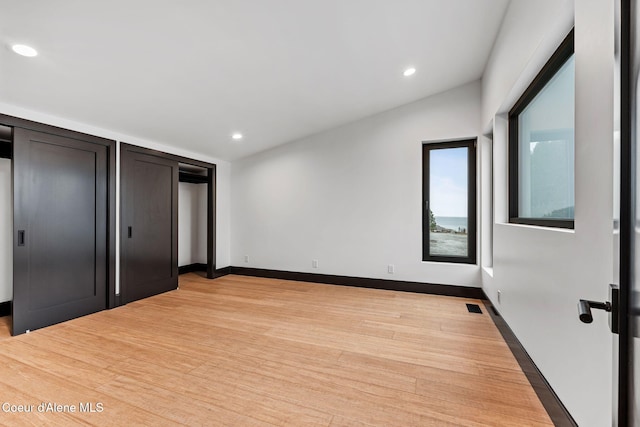1808 Garfield Bay Rd, Sagle, ID 83860 - unfurnished bedroom with recessed lighting, light wood-type flooring, baseboards, and multiple closets