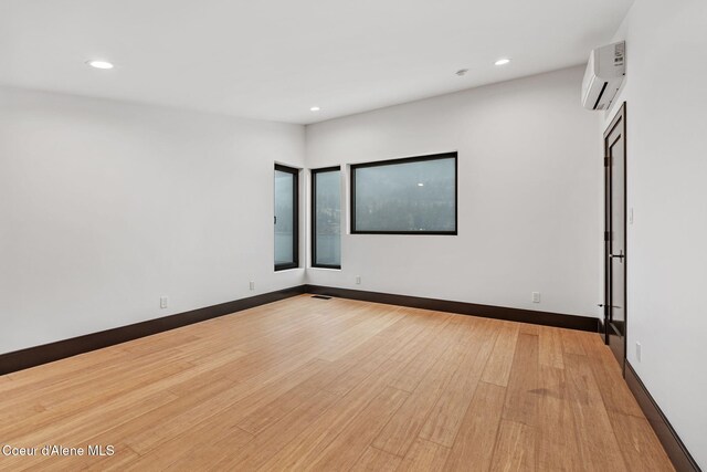 1808 Garfield Bay Rd, Sagle, ID 83860 - unfurnished room with a wall mounted AC, recessed lighting, light wood-style flooring, and baseboards