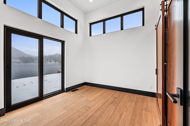 1808 Garfield Bay Rd, Sagle, ID 83860 - unfurnished room featuring light wood-style flooring, baseboards, a water view, and recessed lighting