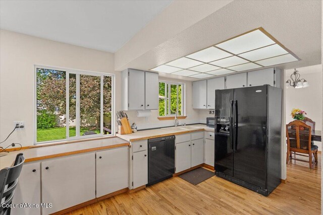 2101 W Bordeaux Ave, Hayden, ID 83835 - kitchen with black appliances, a sink, light wood finished floors, and light countertops