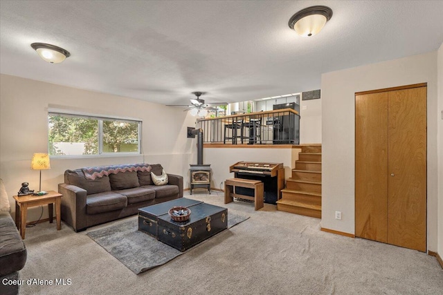 2101 W Bordeaux Ave, Hayden, ID 83835 - living room with a wood stove, carpet, ceiling fan, and stairs