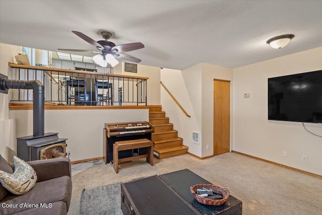 2101 W Bordeaux Ave, Hayden, ID 83835 - living area with a ceiling fan, a wood stove, carpet, stairway, and baseboards