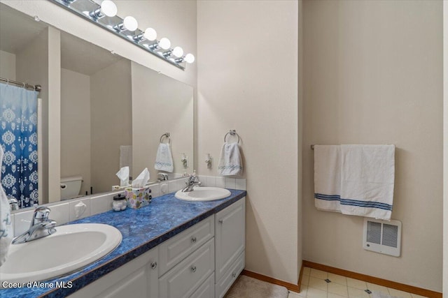 2101 W Bordeaux Ave, Hayden, ID 83835 - bathroom with double vanity, toilet, heating unit, and baseboards