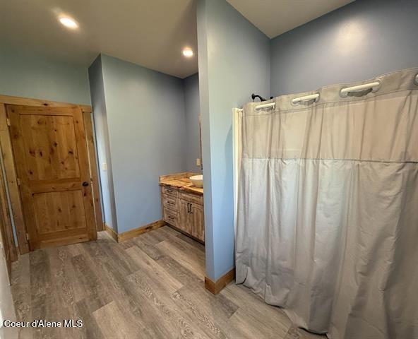 240 Canyon Dr, Kooskia, ID 83539 - bathroom featuring wood finished floors, baseboards, curtained shower, vanity, and recessed lighting