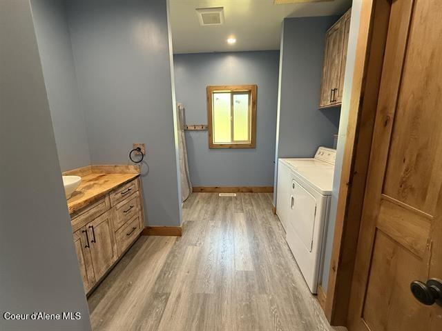 240 Canyon Dr, Kooskia, ID 83539 - laundry room with washing machine and clothes dryer, light wood-type flooring, cabinet space, baseboards, and recessed lighting