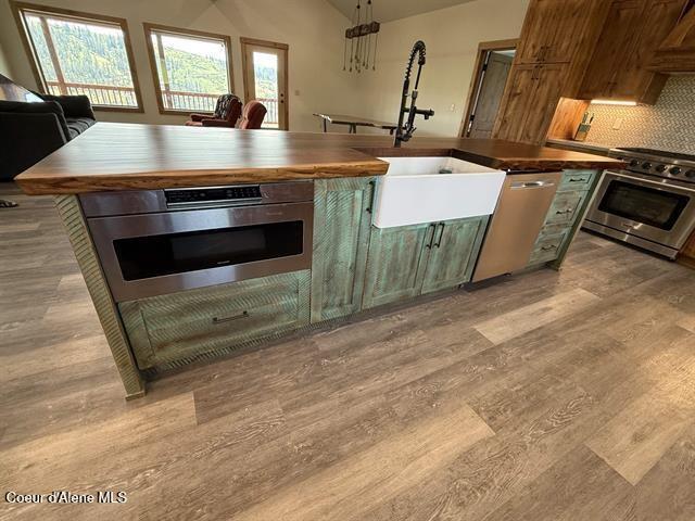 240 Canyon Dr, Kooskia, ID 83539 - kitchen with appliances with stainless steel finishes, light wood-style flooring, wooden counters, a sink, and tasteful backsplash
