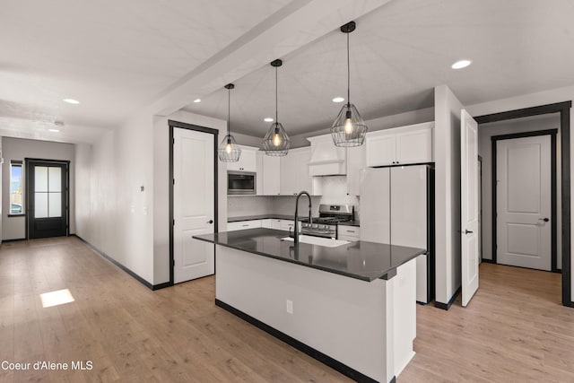 6568 N Downing Ln, Coeur Dalene, ID 83815 - kitchen featuring appliances with stainless steel finishes, a sink, dark countertops, recessed lighting, and light wood-style floors