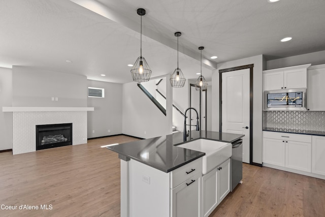 6568 N Downing Ln, Coeur Dalene, ID 83815 - kitchen featuring stainless steel appliances, dark countertops, a sink, decorative backsplash, and recessed lighting