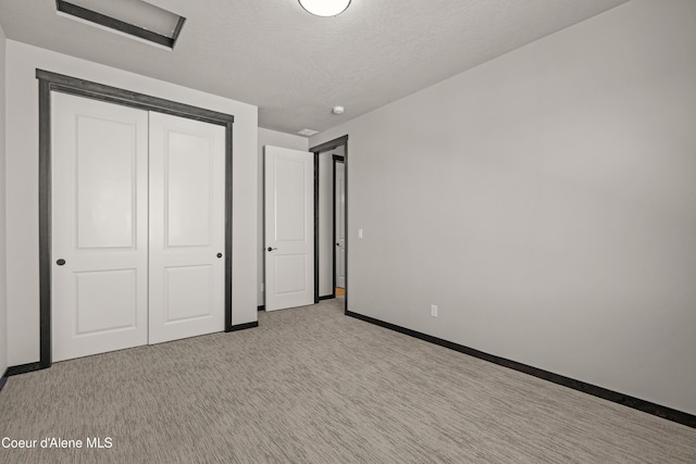 6568 N Downing Ln, Coeur Dalene, ID 83815 - unfurnished bedroom featuring a closet, light carpet, baseboards, and a textured ceiling