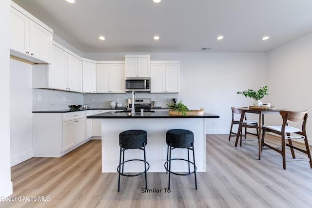 701 N Creative Way, Post Falls, ID 83854 - kitchen featuring stainless steel appliances, dark countertops, a sink, white cabinets, and recessed lighting