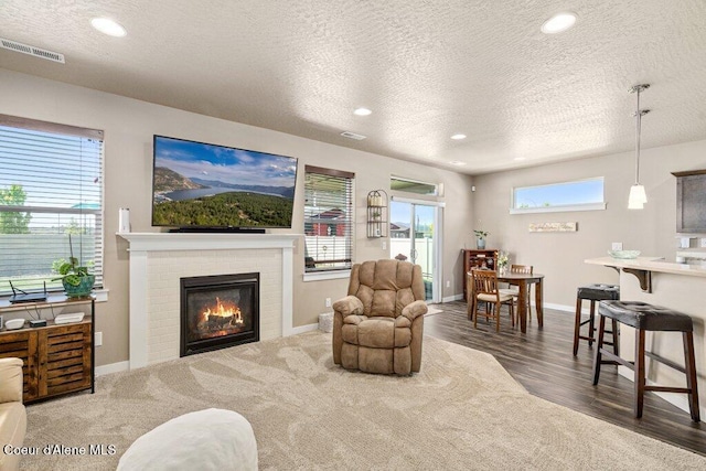 4615 N Connery Loop, Post Falls, ID 83854 - living area featuring a textured ceiling, a fireplace, baseboards, recessed lighting, and wood finished floors