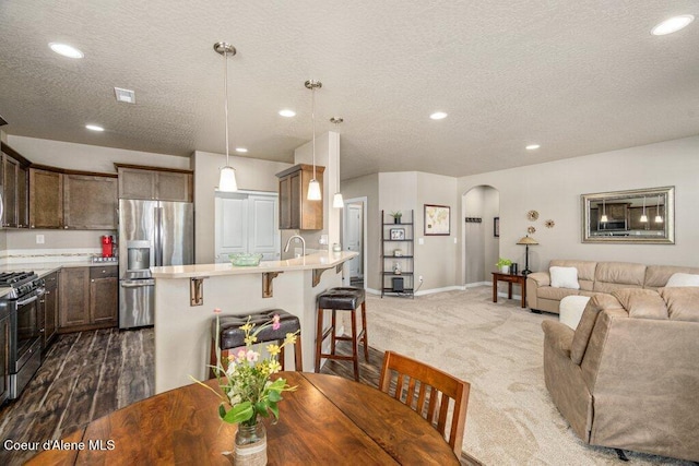 4615 N Connery Loop, Post Falls, ID 83854 - dining area featuring arched walkways, a textured ceiling, recessed lighting, carpet floors, and baseboards