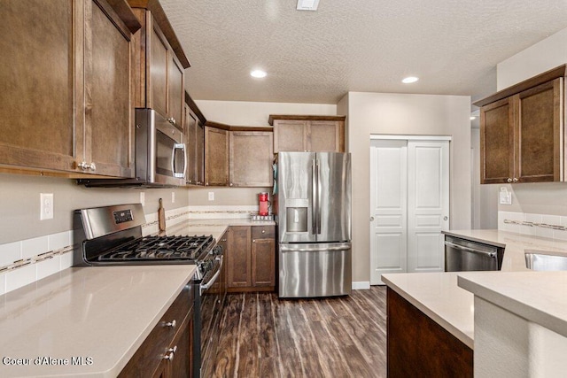 4615 N Connery Loop, Post Falls, ID 83854 - kitchen with appliances with stainless steel finishes, dark wood finished floors, light countertops, a textured ceiling, and recessed lighting
