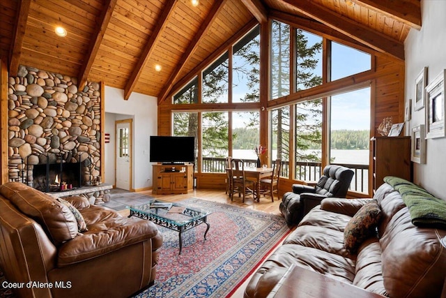 7373 E Hayden Haven Rd, Hayden, ID 83835 - living area featuring high vaulted ceiling, healthy amount of natural light, wood ceiling with exposed beams, a stone fireplace, and light wood finished floors