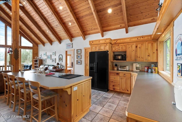 7373 E Hayden Haven Rd, Hayden, ID 83835 - kitchen with wooden ceiling with exposed beams, black appliances, light countertops, a breakfast bar, and high vaulted ceiling