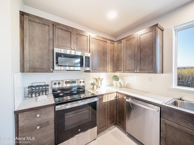 13639 N Apex Way, Hayden, ID 83835 - kitchen with stainless steel appliances, light countertops, backsplash, and dark brown cabinets