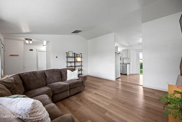 1125 N Shannon Ln, Post Falls, ID 83854 - living area featuring lofted ceiling, light wood finished floors, and baseboards