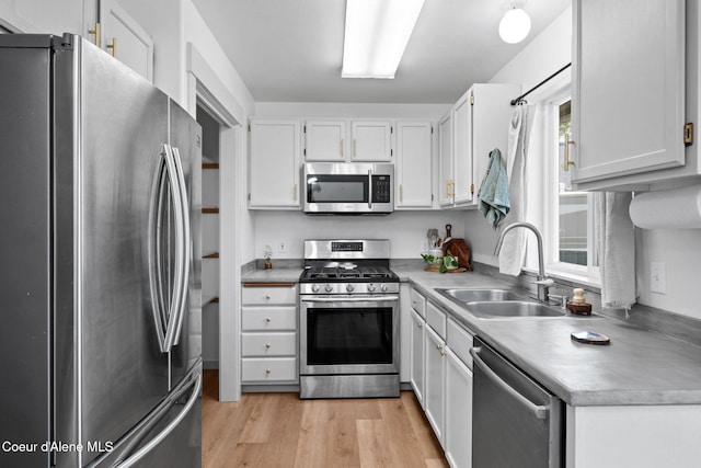 1125 N Shannon Ln, Post Falls, ID 83854 - kitchen with appliances with stainless steel finishes, a sink, light wood-type flooring, and white cabinets