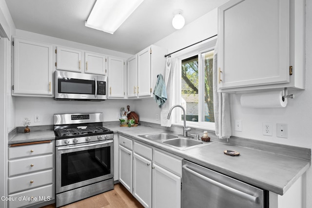 1125 N Shannon Ln, Post Falls, ID 83854 - kitchen featuring appliances with stainless steel finishes, a sink, white cabinetry, light countertops, and light wood-type flooring