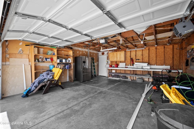 1125 N Shannon Ln, Post Falls, ID 83854 - garage featuring stainless steel fridge with ice dispenser and a workshop area