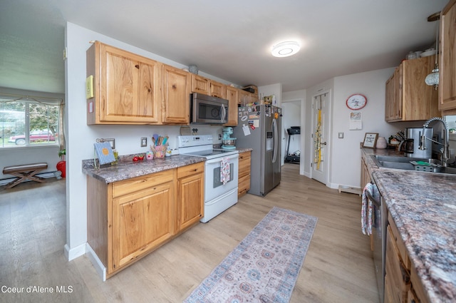 1707 E 2nd Ave, Post Falls, ID 83854 - kitchen with stainless steel appliances, a sink, light wood-type flooring, and baseboards