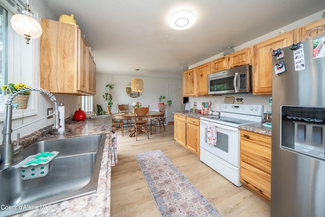 1707 E 2nd Ave, Post Falls, ID 83854 - kitchen with appliances with stainless steel finishes, a sink, light wood-style floors, and pendant lighting