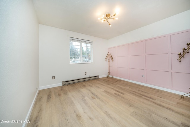 1707 E 2nd Ave, Post Falls, ID 83854 - unfurnished room with a baseboard radiator, light wood-type flooring, a chandelier, a decorative wall, and baseboards