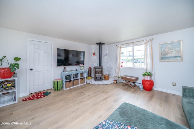 1707 E 2nd Ave, Post Falls, ID 83854 - living area with a wood stove, wood finished floors, and baseboards