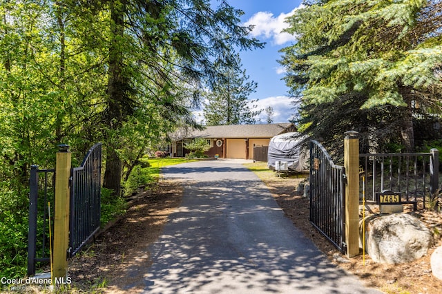 7485 E Revilo Point Rd, Hayden, ID 83835 - view of front of property featuring driveway, a gate, and an attached garage