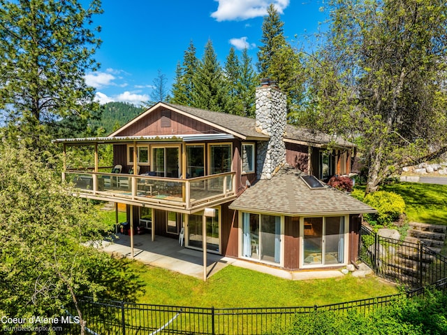 7485 E Revilo Point Rd, Hayden, ID 83835 - back of house with a chimney, a sunroom, a patio, and a shingled roof