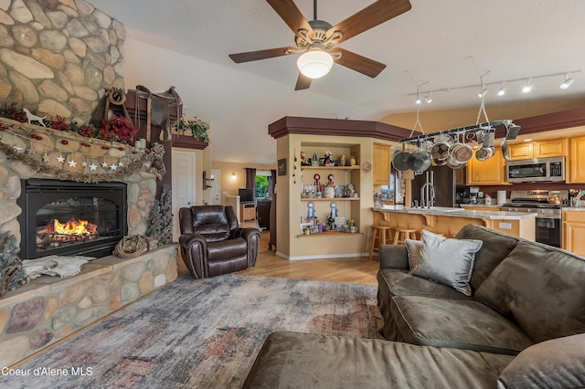 222 E Remington Rd, Athol, ID 83801 - living area featuring light wood-style flooring, ceiling fan, a fireplace, vaulted ceiling, and baseboards