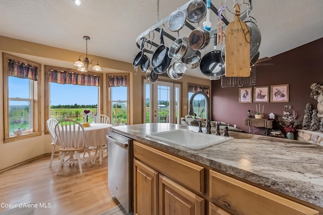 222 E Remington Rd, Athol, ID 83801 - kitchen featuring a sink, dishwasher, light wood-type flooring, hanging light fixtures, and dark countertops