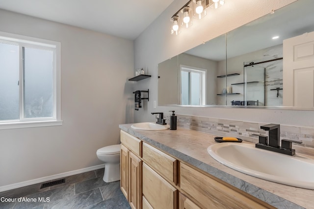 222 E Remington Rd, Athol, ID 83801 - bathroom with baseboards, a stall shower, toilet, tasteful backsplash, and double vanity