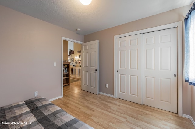 222 E Remington Rd, Athol, ID 83801 - unfurnished bedroom featuring light wood-style floors, baseboards, a closet, and a textured ceiling