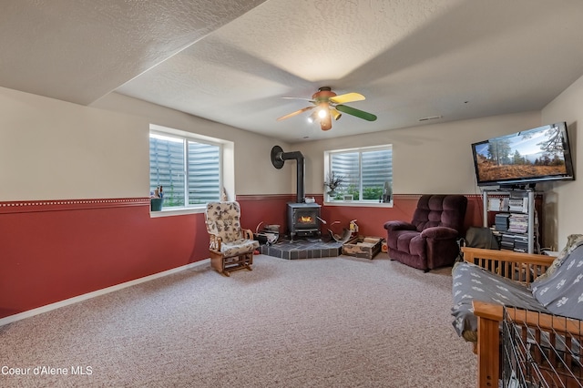 222 E Remington Rd, Athol, ID 83801 - living area with a wood stove, carpet floors, a ceiling fan, a textured ceiling, and baseboards