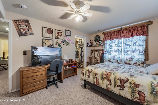 222 E Remington Rd, Athol, ID 83801 - bedroom with light carpet, a walk in closet, a desk, a closet, and ceiling fan