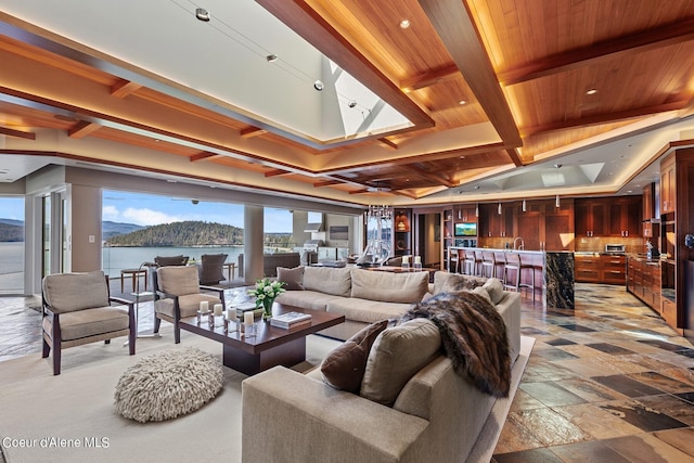2051 S Island Green Dr, Coeur Dalene, ID 83814 - living area featuring coffered ceiling, a water view, stone tile floors, and wood ceiling with exposed beams