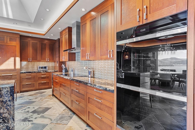 2051 S Island Green Dr, Coeur Dalene, ID 83814 - kitchen with wall chimney exhaust hood, dark stone countertops, brown cabinets, tasteful backsplash, and recessed lighting