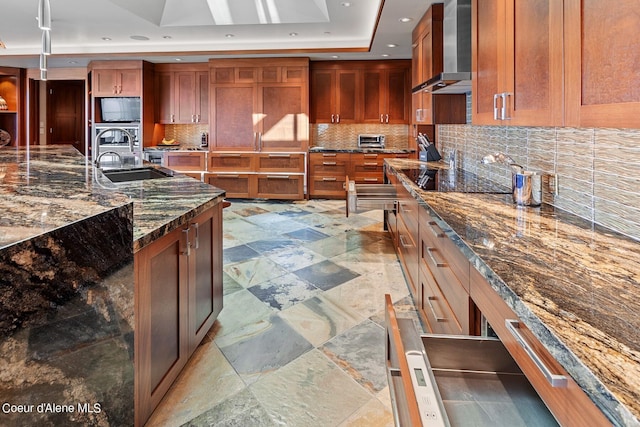 2051 S Island Green Dr, Coeur Dalene, ID 83814 - kitchen featuring wall chimney exhaust hood, a sink, a tray ceiling, dark stone countertops, and recessed lighting