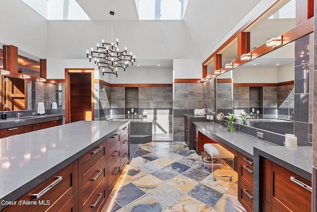 2051 S Island Green Dr, Coeur Dalene, ID 83814 - kitchen with dark countertops, high vaulted ceiling, a skylight, tile walls, and pendant lighting