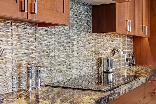 2051 S Island Green Dr, Coeur Dalene, ID 83814 - kitchen view of backsplash, brown cabinets, dark stone countertops, and exhaust hood
