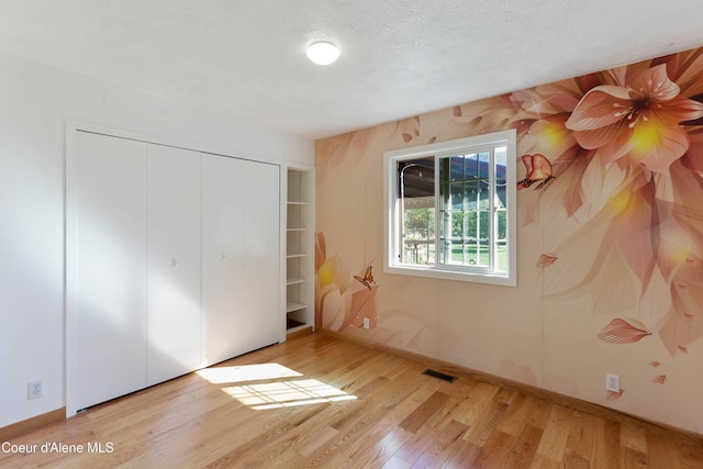 6264 N 15th St, Dalton Gardens, ID 83815 - unfurnished bedroom with wood finished floors, a closet, and baseboards