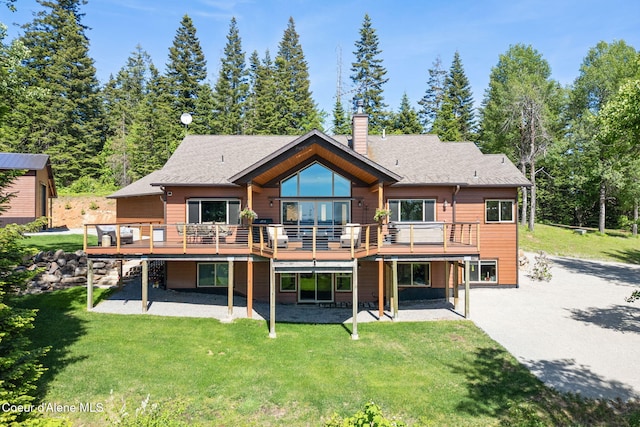 17378 N Freddi Rd, Rathdrum, ID 83858 - rear view of property featuring a patio area, a wooden deck, a chimney, a lawn, and a shingled roof