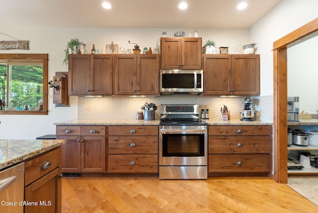 17378 N Freddi Rd, Rathdrum, ID 83858 - kitchen with stainless steel appliances, light wood-style floors, backsplash, and recessed lighting