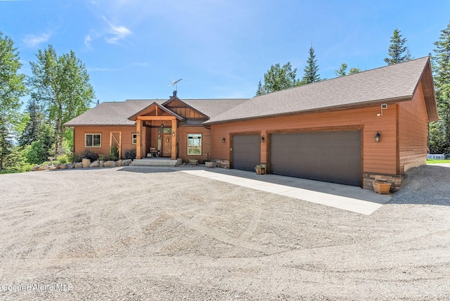 17378 N Freddi Rd, Rathdrum, ID 83858 - view of front facade featuring dirt driveway, a garage, roof with shingles, and stone siding