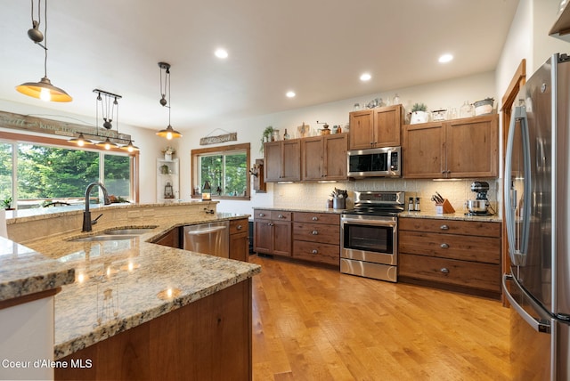 17378 N Freddi Rd, Rathdrum, ID 83858 - kitchen featuring stainless steel appliances, a sink, brown cabinets, decorative backsplash, and recessed lighting
