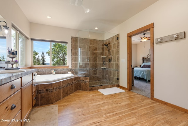 17378 N Freddi Rd, Rathdrum, ID 83858 - ensuite bathroom with wood finished floors, tiled shower, a bath, vanity, and recessed lighting