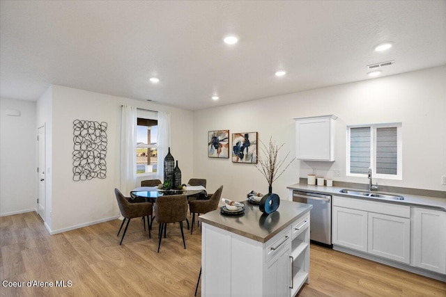 5082 E Norma Ave, Post Falls, ID 83854 - kitchen featuring dishwasher, a sink, light wood finished floors, white cabinetry, and recessed lighting