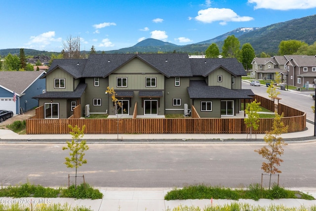 1674 Onyx Ct, Sandpoint, ID 83864 - view of front facade with a mountain view, a fenced front yard, and board and batten siding